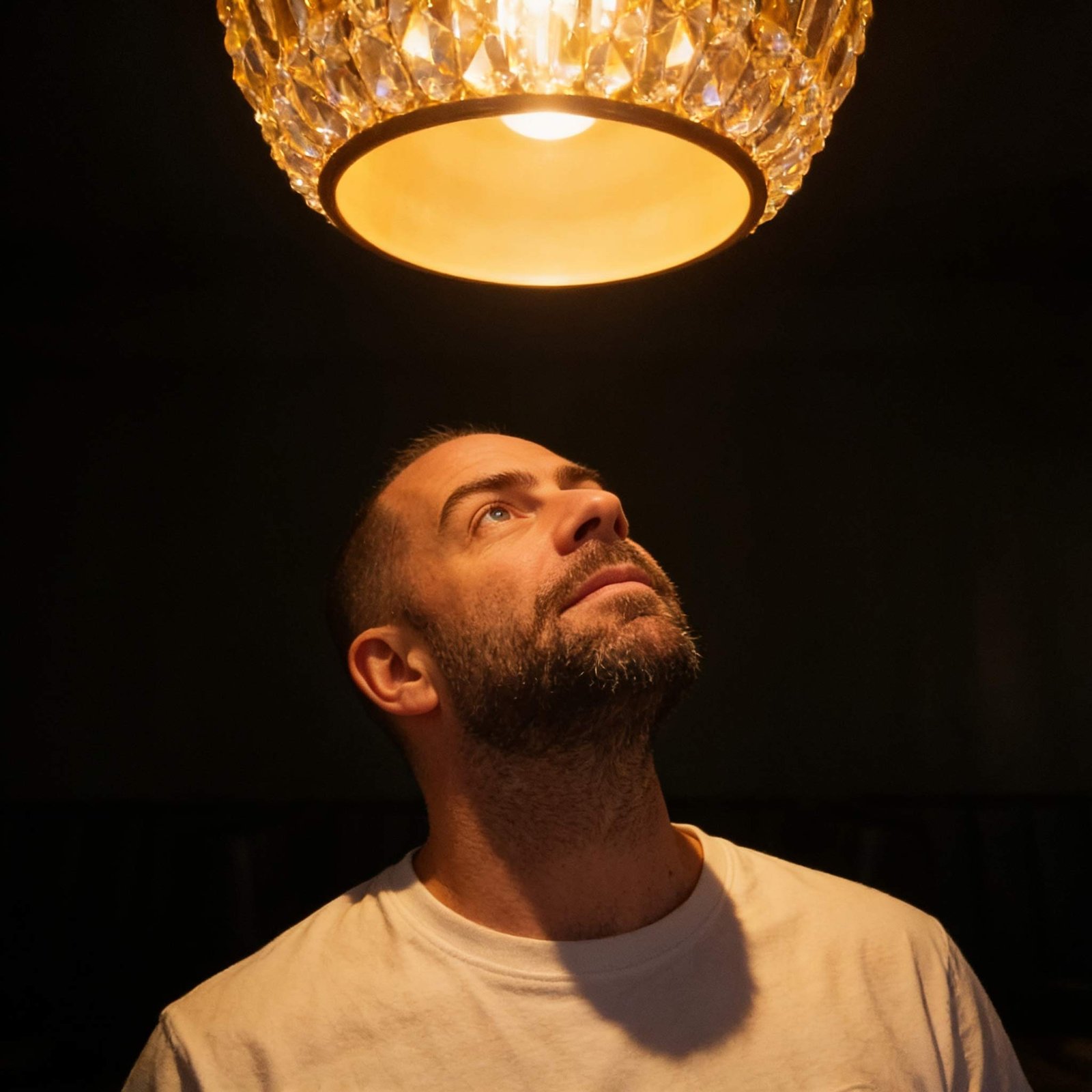 Ben Weldon, founder of South West Lighting Design, looking up at a crystal pendant light